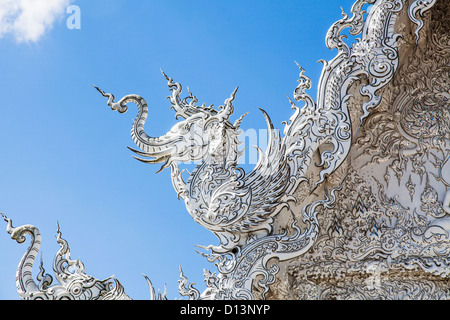 Wat Rong Khun oder weiße Tempel, Chiang Rai, Nordthailand.  Dachdetails vor einem strahlend blauen Himmel Stockfoto