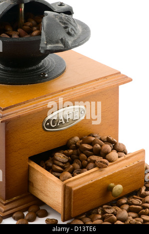 hölzerne Kaffeemühle mit Bohnen auf weiß Stockfoto