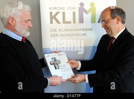 Nobelpreis Laureatus Olav Hohmeyer (L) der Universität Flensburg übergibt die neuen Klimaschutzkonzept der Evangelisch-Lutherischen Kirche von Norddeutschland an die Bischöfe Vertreter Gothart Magaard an den Landtag in Kiel, Deutschland, 6. Dezember 2012. Foto: Carsten Rehder Stockfoto