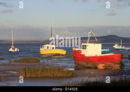 Kleine Boote verankert am Rand der Gezeiten an der Küste in Morecambe, Lancashire, England. Stockfoto