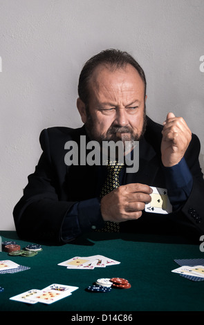 Mann beim Pokerspiel zu betrügen. Er legt ein Ass im Ärmel Stockfoto
