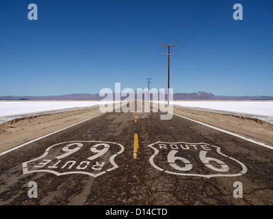 Route 66 Schild auf grobe Mojave-Wüste Salz flache Autobahn Pflaster gemalt. Stockfoto