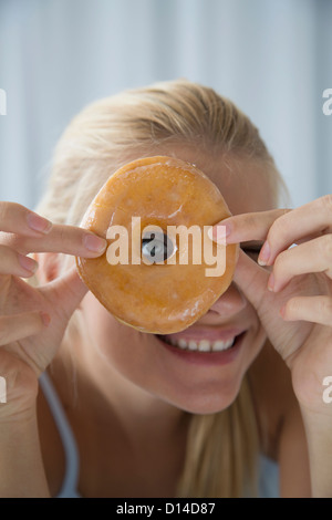 Frau spähte durch Donut-Loch Stockfoto