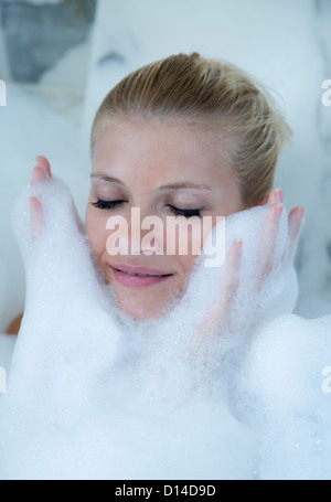 Frau spielt im Schaumbad Stockfoto