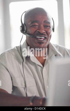 Unternehmer tragen Kopfhörer am Schreibtisch Stockfoto