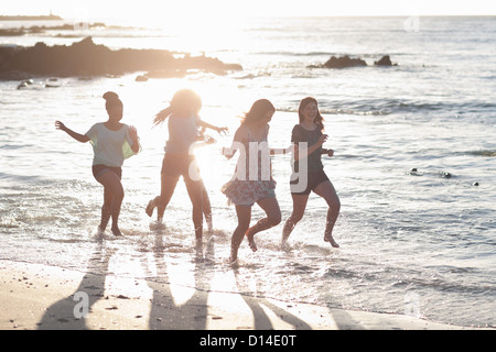 Frauen laufen zusammen am Strand Stockfoto