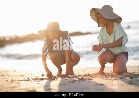 Frauen, die Zeichnung im Sand am Strand Stockfoto