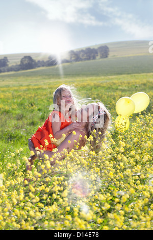 Schwestern, die im Bereich der Blumen spielen Stockfoto