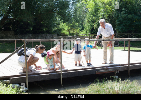 Familie Prüfung Fluss auf Brücke Stockfoto