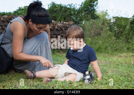 Mutter Knaben Knie Bandage anziehen Stockfoto