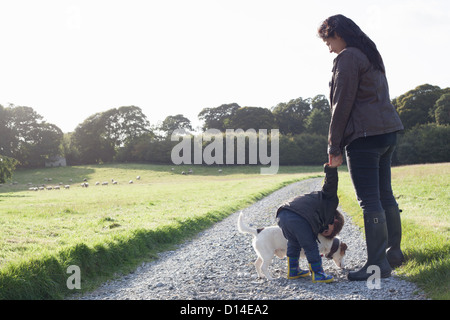 Mutter und Sohn gehen Hund auf Feldweg Stockfoto