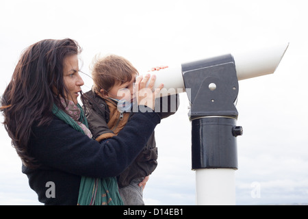 Mutter und Sohn suchen durch Teleskop Stockfoto