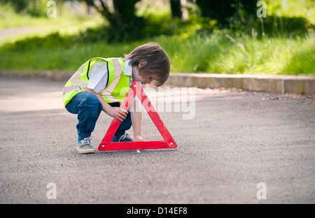 Jungen spielen Verkehr Arbeiter auf Landstraße Stockfoto