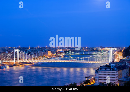 Blick über die Stadt Budapest bei Dämmerung mit beleuchteten Brücken über die Donau in Ungarn. Stockfoto