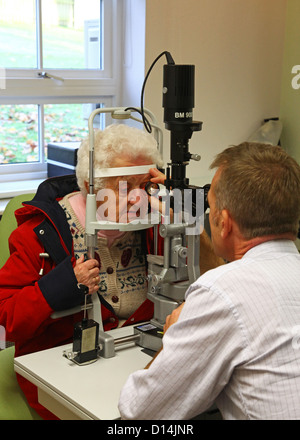 Eine alte Frau, die ihre Augen für Katarakte durch einen Berater Augenarzt getestet Stockfoto