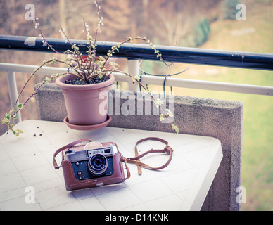 Vintage sowjetische analoge Kamera (gefüttert-5v) in seine braune Ledertasche, auf einen weißen Balkontisch legen Stockfoto