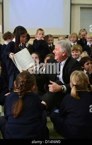 Headmaster James Devine Gespräch mit Kindern in Morgen Versammlung in Our Lady & St. Werburgh's katholische Grundschule in Newcastl Stockfoto