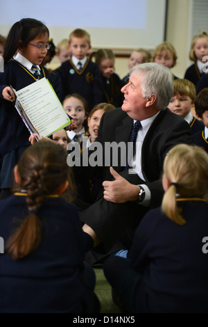 Headmaster James Devine Gespräch mit Kindern in Morgen Versammlung in Our Lady & St. Werburgh's katholische Grundschule in Newcastl Stockfoto