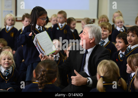 Headmaster James Devine Gespräch mit Kindern in Morgen Versammlung in Our Lady & St. Werburgh's katholische Grundschule in Newcastl Stockfoto