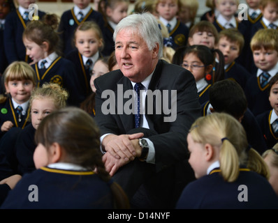 Headmaster James Devine Gespräch mit Kindern in Morgen Versammlung in Our Lady & St. Werburgh's katholische Grundschule in Newcastl Stockfoto