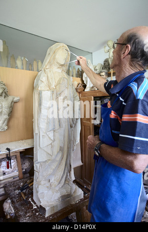 Bildhauer bewundern Holzfigur Stockfoto