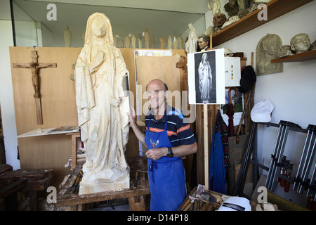 Bildhauer stehend mit Holzfigur Stockfoto