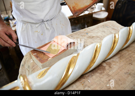 Arbeiter, die Anwendung von Blattgold auf pole Stockfoto