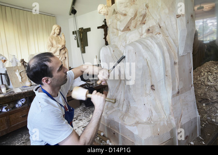 Bildhauer Meißeln Figur aus Holz Stockfoto