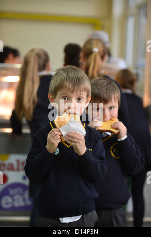 Ein Schuljunge Essen Toast nach Morgen Versammlung in Our Lady & St. Werburgh's katholische Grundschule in Newcastle-under-Lyme, St Stockfoto