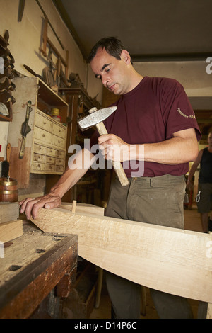 Arbeiter Hämmern Nagel ins Holz Stockfoto