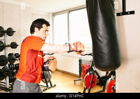 Mann mit Boxsack in Turnhalle Stockfoto