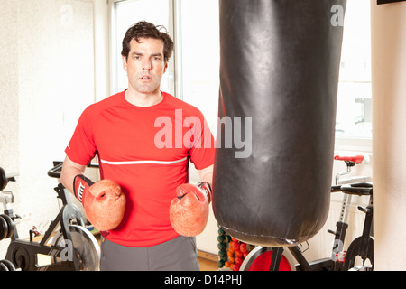 Mann mit Boxsack in Turnhalle Stockfoto