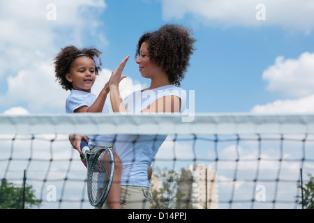 Mutter und Tochter hohe Fiving auf Platz Stockfoto