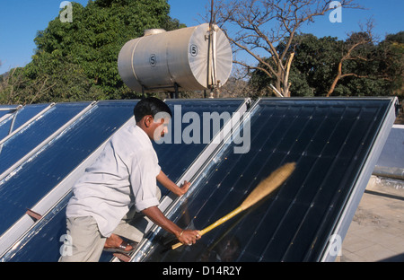 Indien Rajasthan, Mann sauber Solarkollektor in Brahma Kumari Ashram in Mt. Abu, Sonnenkollektor wird verwendet, um Warmwasser zu bekommen Stockfoto