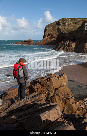 Auf Felsen am Plemont Beach, Jersey stehende Person; Kanalinseln, Großbritannien Stockfoto