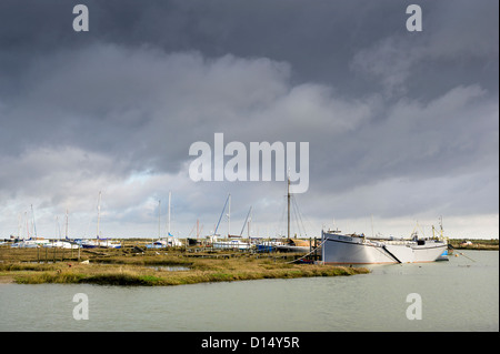 Die Boote vertäuten auf Schlammplätzen in der stimmungsvollen Tollesbury Saltings in Essex. Stockfoto