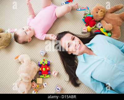 USA, New Jersey, Jersey City, Mutter mit Tochter (6-11 Monate) am Boden liegend Stockfoto