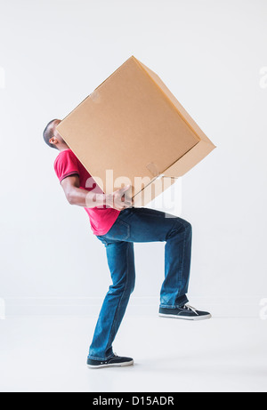 Studioaufnahme von junger Mann mit großen Karton Stockfoto