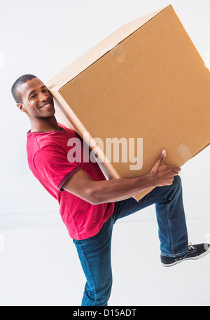 Studioaufnahme von junger Mann mit großen Karton Stockfoto