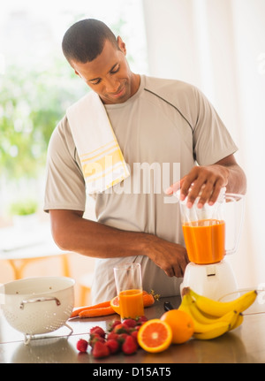 USA, New Jersey, Jersey City, junger Mann bereitet Smoothie aus frischen Früchten Stockfoto