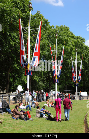 Menschen entspannen auf dem Rasen neben Victoria Memorial nach Trooping the Colour, London, England Stockfoto