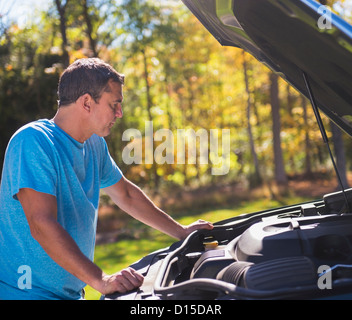 USA, New Jersey, Mendham, Mann stützte sich auf Auto mit Kapuze öffnen am Straßenrand Stockfoto