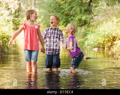 USA, Utah, Lehi, drei Kinder (4-5, 6 und 7) spielen zusammen in kleinen Bach Stockfoto