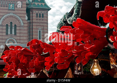 Symbolische Dekorationen für die Weihnachtszeit, als Symbol für Geweih aus rotem Samt. Im Hintergrund eine Kirche. Stockfoto