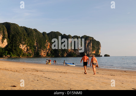 Touristen zu Fuß am Meer Sonnenuntergang Ao Nang Strand Krabi Thailand Andaman Meer tropisches Paradies Stockfoto