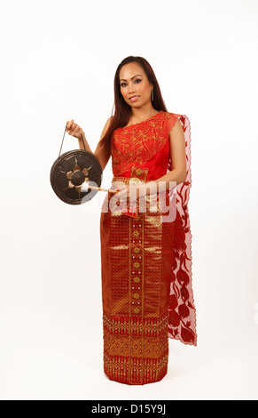 Junge schöne Thai Frau in einem roten und goldenen satin Kleid, einen Thai Gong spielen Stockfoto