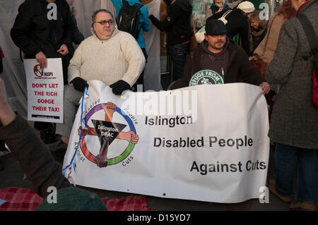 8. Dezember 2012 London UK. Mitglieder der UK Uncut und Islington behinderte Menschen gegen Kürzungen protestieren gegen corporate Steuerhinterziehung außerhalb der Upper Street Filiale von Starbucks in Islington, Nordlondon. Demonstranten lenkte die Aufmerksamkeit auf Sparmaßnahmen, die obdachlos sind Personen während Großunternehmen nutzen Gesetzeslücken, um große Steuer-Rechnungen zu vermeiden. Stockfoto