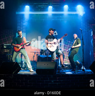 Musiker spielt eine Gitarre auf einem dunklen Hintergrund Stockfoto