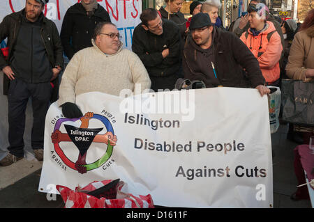 8. Dezember 2012 London UK. Mitglieder der UK Uncut und Islington behinderte Menschen gegen Kürzungen protestieren gegen corporate Steuerhinterziehung außerhalb der Upper Street Filiale von Starbucks in Islington, Nordlondon. Demonstranten lenkte die Aufmerksamkeit auf Sparmaßnahmen, die obdachlos sind Personen während Großunternehmen nutzen Gesetzeslücken, um große Steuer-Rechnungen zu vermeiden. Stockfoto