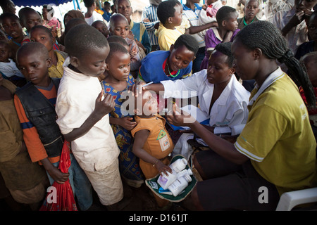 Kinder in die Warteschlange für Entwurmung Medikamente eine Immunisierung Outreach Camp in Kitugutu Dorf, Kyenjojo District, Uganda. Stockfoto